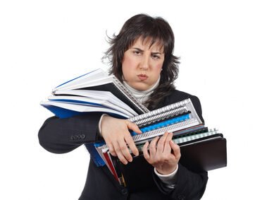 Busy business woman carrying stacked files