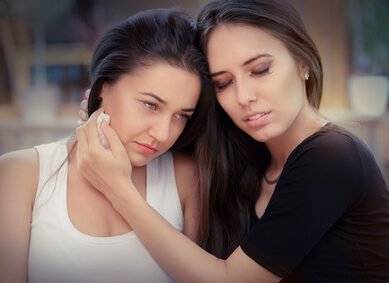 Young woman comforting tearful friend