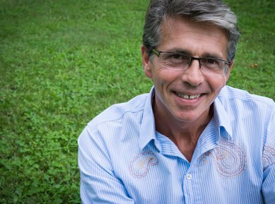 homme souriant assis dans l'herbe