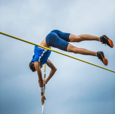 Below shot of a male athlete in pole vault competition